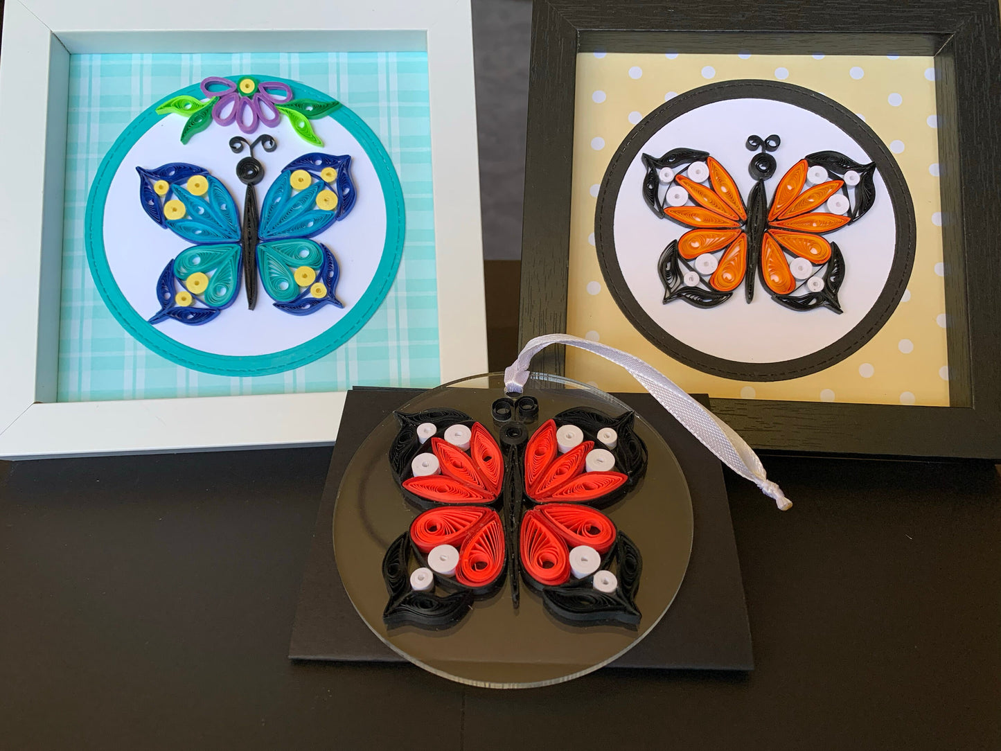 Three quilled butterflies in frames.